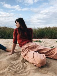 Side view of woman sitting on beach