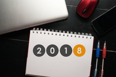 High angle view of calendar with pens and technology on table