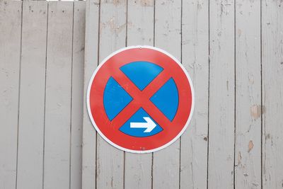 Close-up of no parking sign on wooden wall