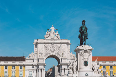 Low angle view of statue against blue sky