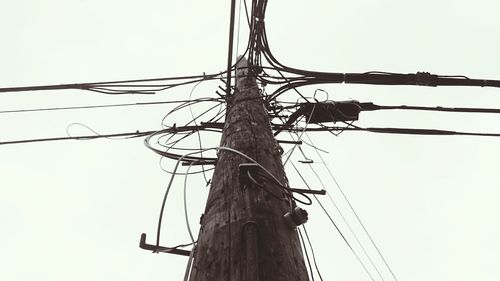 Low angle view of electricity pylon against clear sky