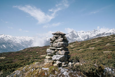 Stack of rocks on mountain against sky