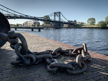 An old thick anchor chain lies on the harbour wall