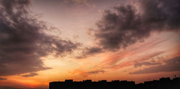 Silhouette of building against dramatic sky