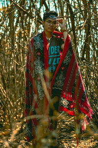 Portrait young man standing in forest