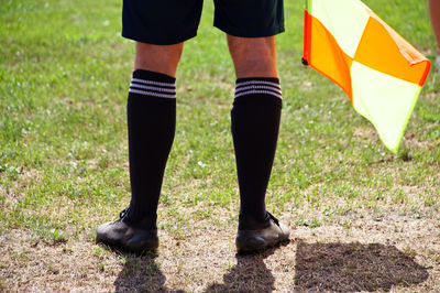 Low section of soccer player with flag standing on field