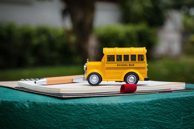 Close-up of toy school bus on book