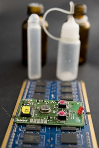 Close-up of circuit board and bottles on table