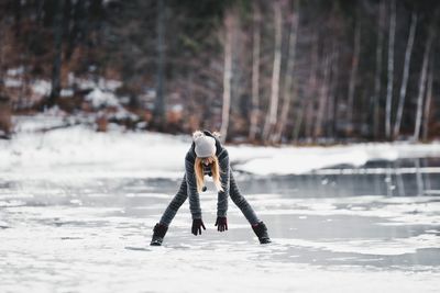 Full length of woman standing on frozen lake
