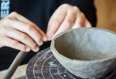 Close-up of person making clay bowl