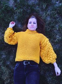 Portrait of young woman lying on field