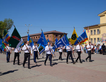 People on street against blue sky