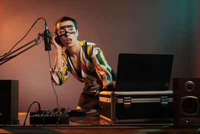 Young man using mobile phone in recording studio