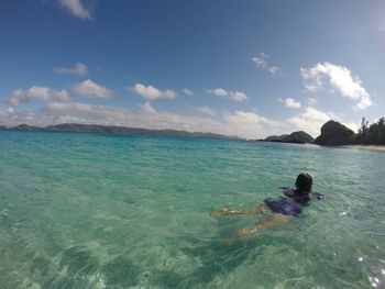 Woman swimming in sea against sky