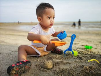 Boy playing with toys on beach