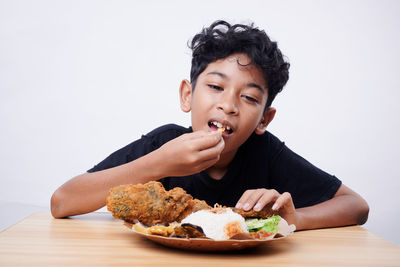 Portrait of young woman eating food at home