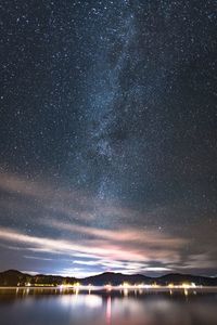 Scenic view of lake against sky at night