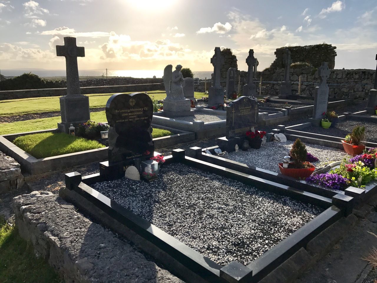 PEOPLE AT CEMETERY AGAINST SKY