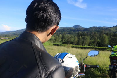 Rear view of man on field against sky