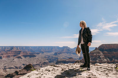 Woman standing on rock against sky