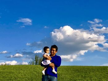 Boy standing on field against sky
