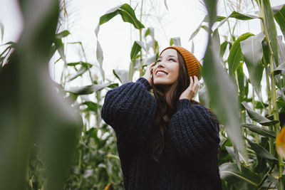 Young woman standing amidst plants