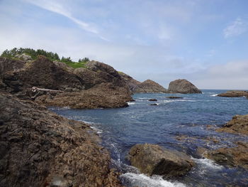 Scenic view of rocks in sea against sky