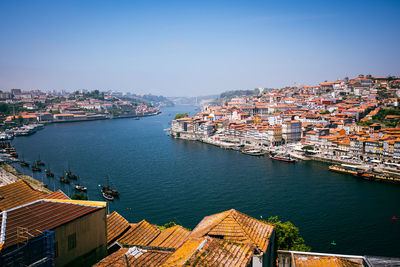 High angle view of townscape by sea against clear sky