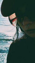 Close-up of woman by sea against sky