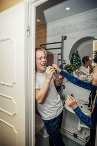 Playful boy brushing teeth in bathroom