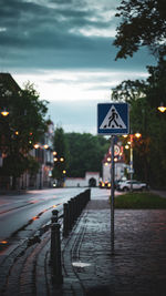 View of a wet street with a crosswalk sign