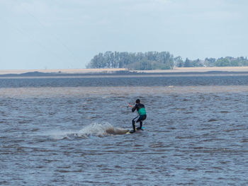 Man surfing in sea against sky