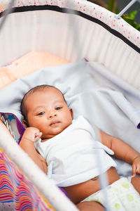 High angle view of cute baby boy sleeping on bed at home