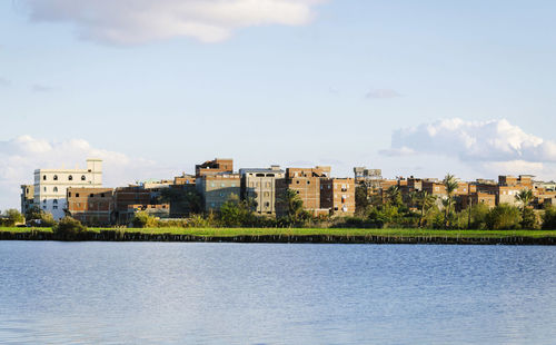 City by river against sky