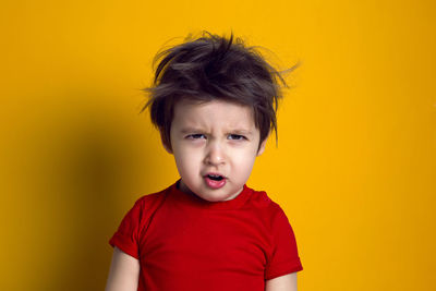 Close-up of boy against yellow background