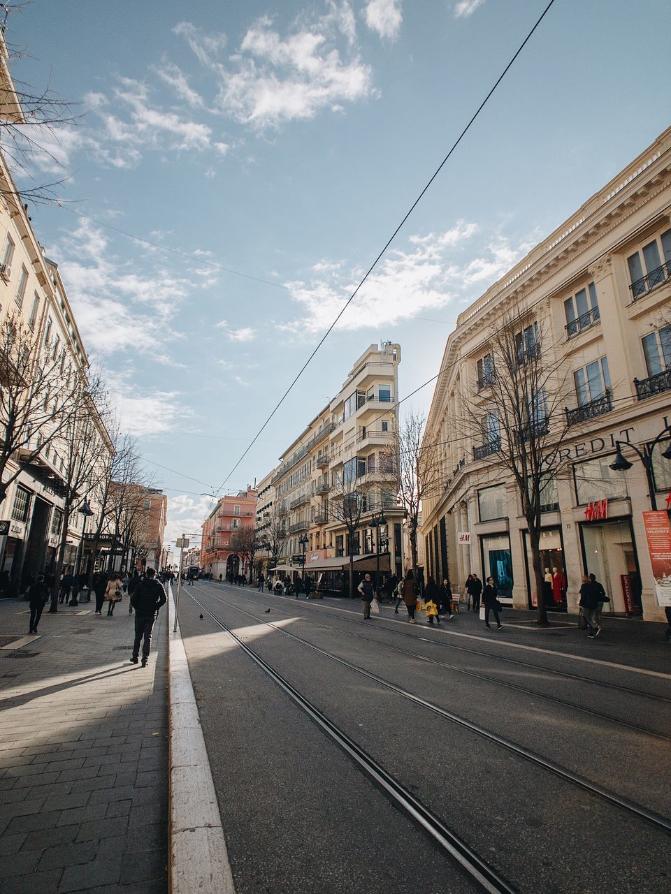 building exterior, architecture, city, built structure, sky, street, transportation, cloud - sky, nature, building, city life, group of people, real people, road, day, city street, walking, track, residential district, railroad track, outdoors