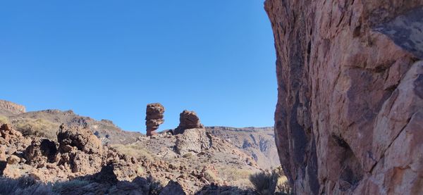 View of rocks against clear blue sky