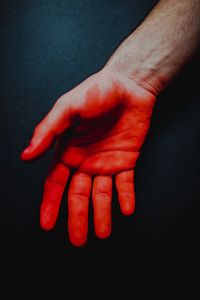 Close-up of human hand against black background