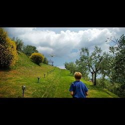 Scenic view of grassy field against cloudy sky