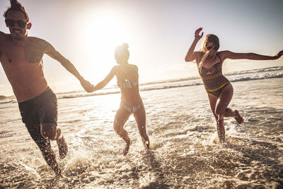 Happy friends enjoying on shore at beach