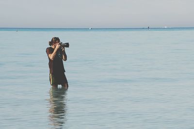 Full length of man holding sea against sky