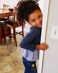 Portrait of smiling girl standing at home