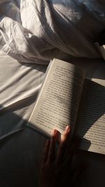 Cropped hand of woman reading book