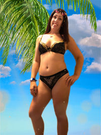 Young woman in bikini standing by swimming pool