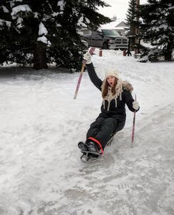 Full length of woman with arms raised in winter