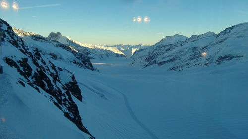 Scenic view of snow covered mountains against sky