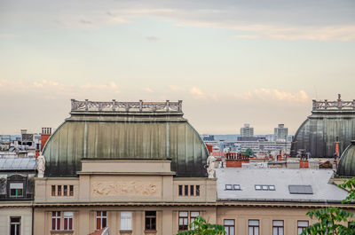 Buildings in city against cloudy sky