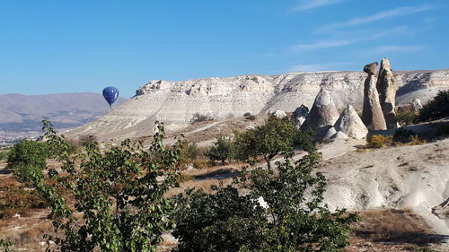 Low angle view of rocky mountains against blue sky