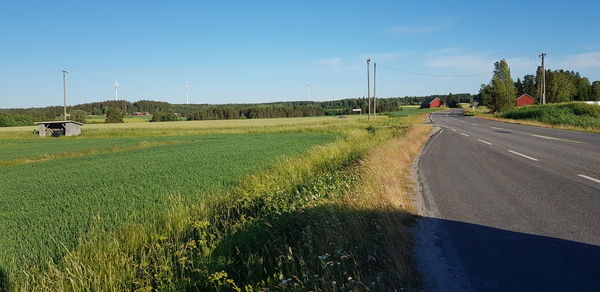 Road amidst field against sky