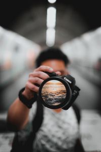 Midsection of man holding camera